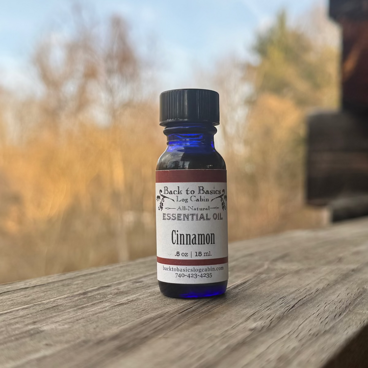 Bottle of cinnamon essential oil on a wooden surface with a blurred natural background