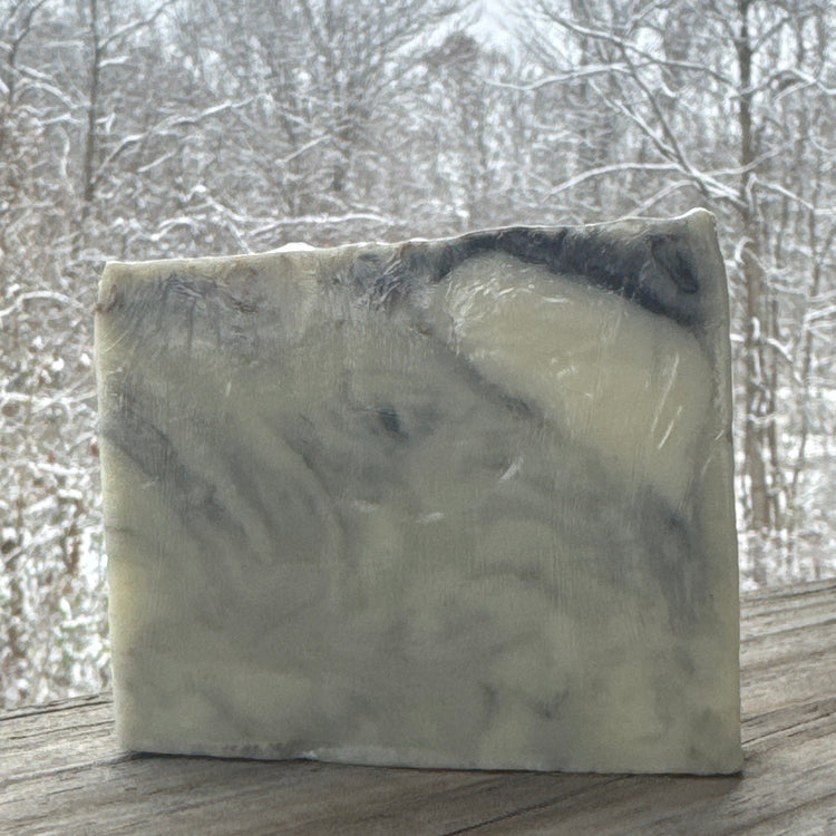 Bar of soap with a marbled pattern on a wooden surface