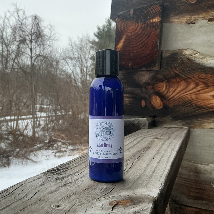 Blue bottle of body lotion on a wooden surface with a snowy landscape in the background