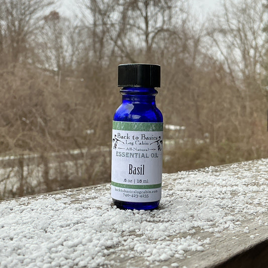 Bottle of basil essential oil on a wooden surface with snowflakes