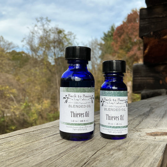 Two bottles of Bach to Basics Thieves Oil on a wooden surface with a natural background