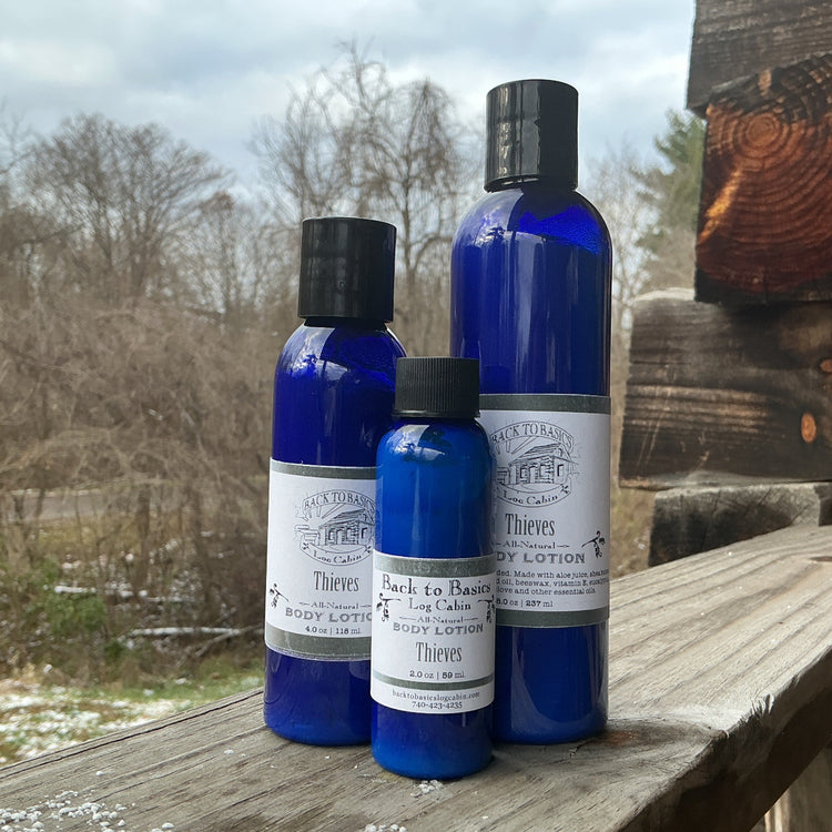 Three blue bottles with black caps on a wooden surface outdoors