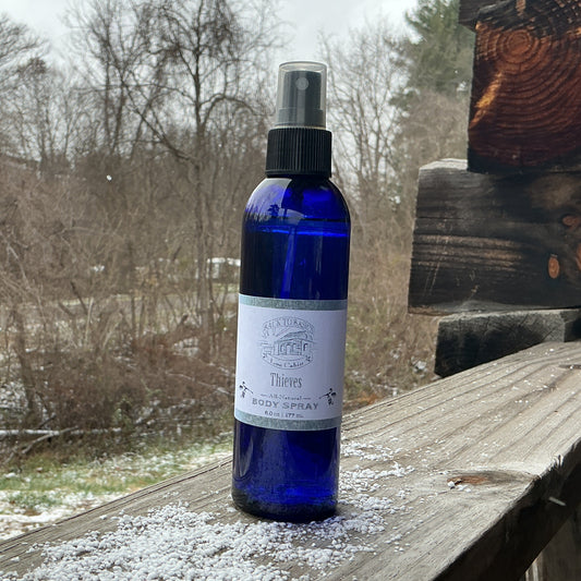 Blue spray bottle with a label on a wooden surface outdoors