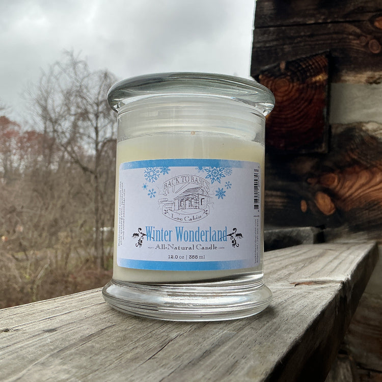 Candle in a glass jar with a label on a wooden surface outdoors
