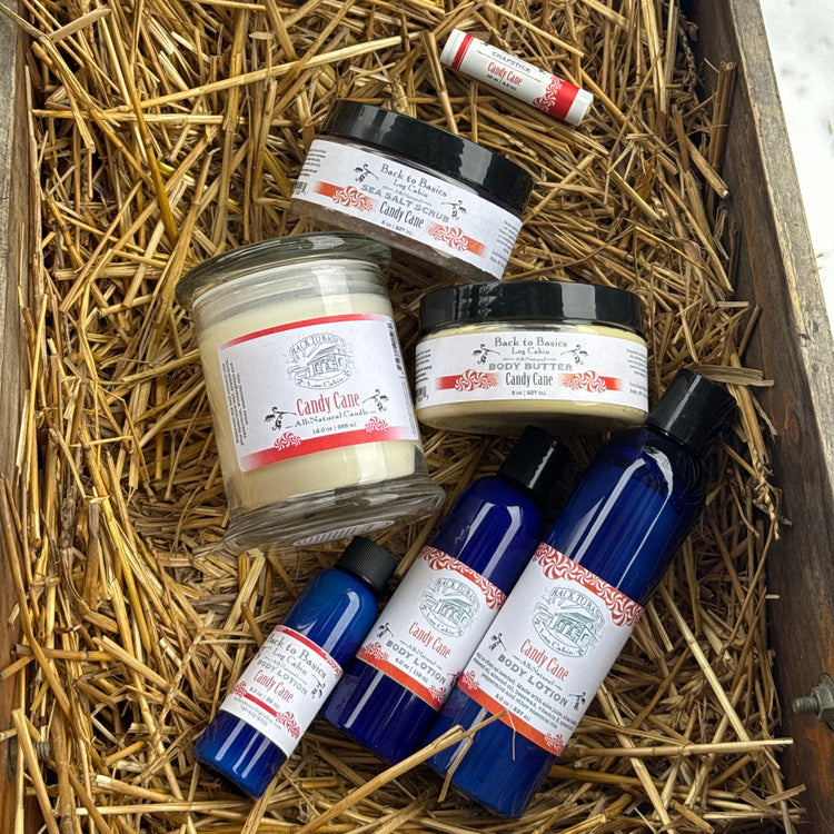 Assorted jars and bottles with labels on a bed of straw in a wooden box.