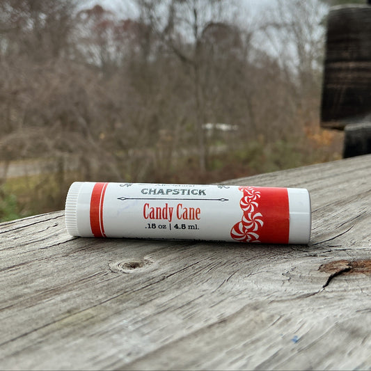 Chapstick Candy Cane flavor on a wooden surface with a natural background