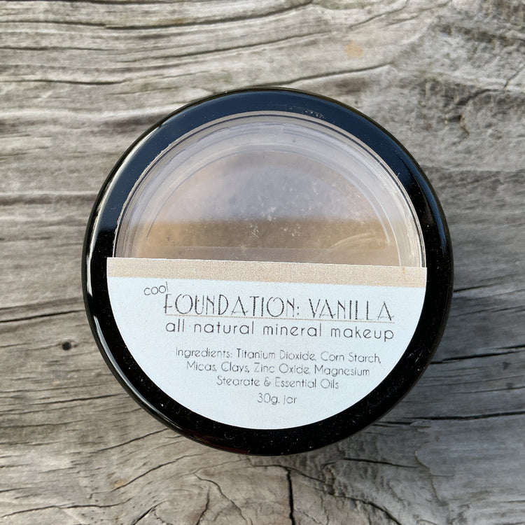 Jar of foundation makeup on a wooden surface
