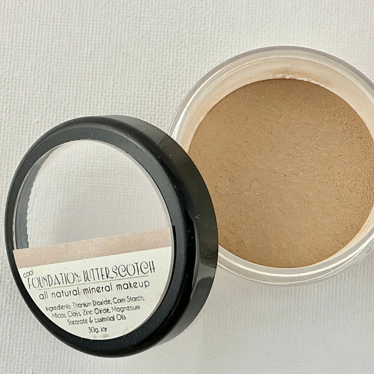 Open container of foundation with visible label on a light background