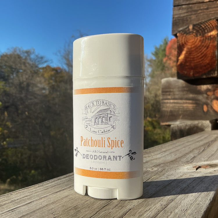 Deodorant stick labeled 'Patchouli Spice' on a wooden surface with a natural background
