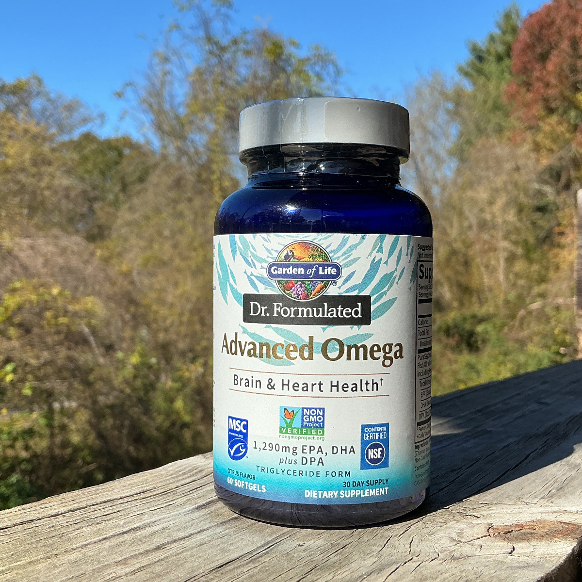 Supplement bottle labeled 'Dr. Formulated Advanced Omega' on a wooden surface with a natural background