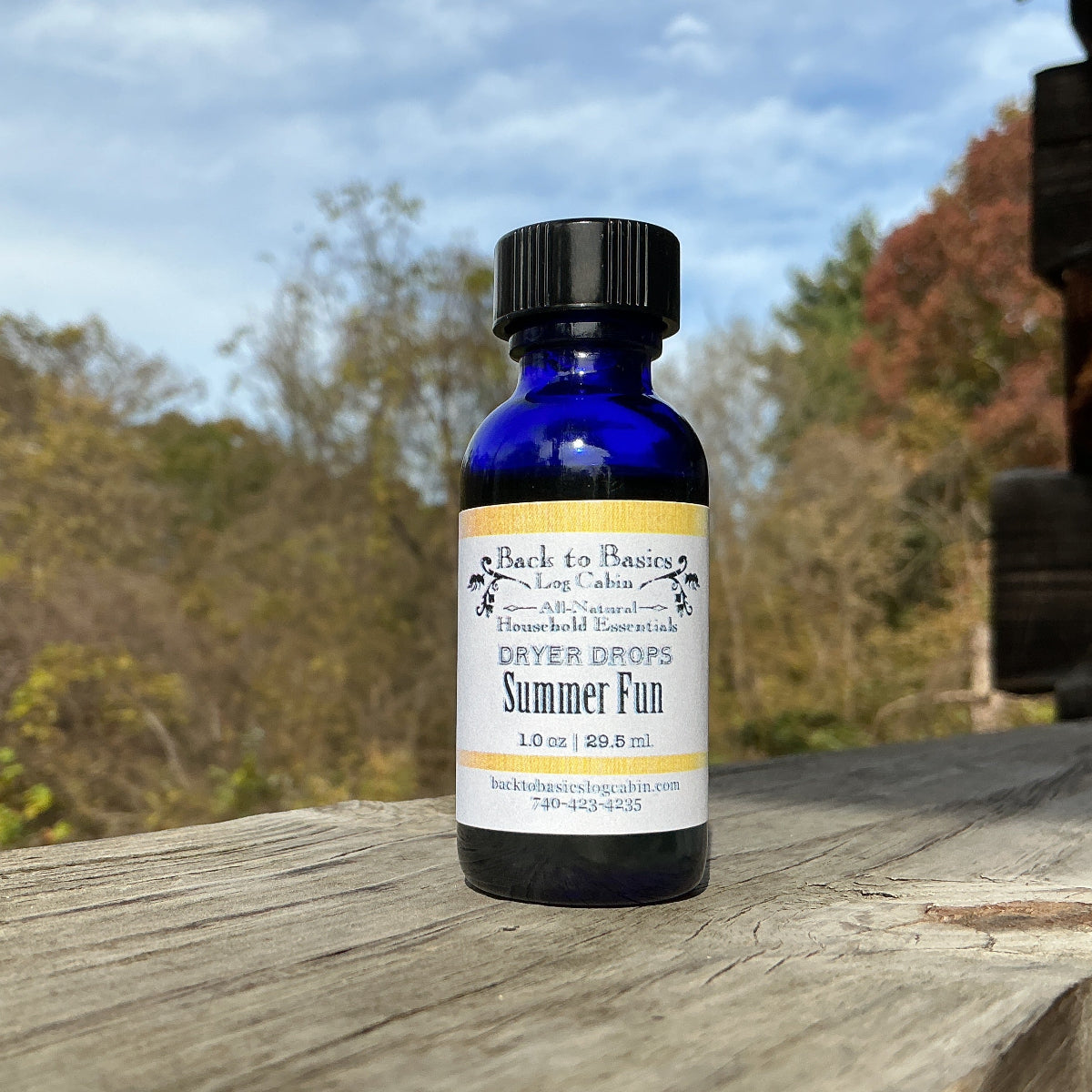 Bottle of 'Summer Fun' essential oil on a wooden surface with a natural background