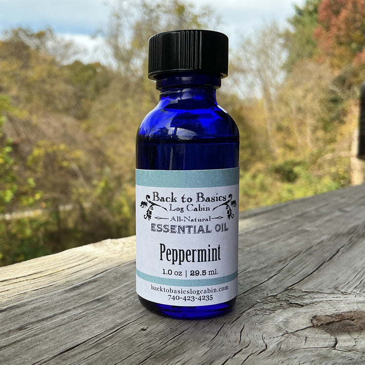 Bottle of peppermint essential oil on a wooden surface with a natural background