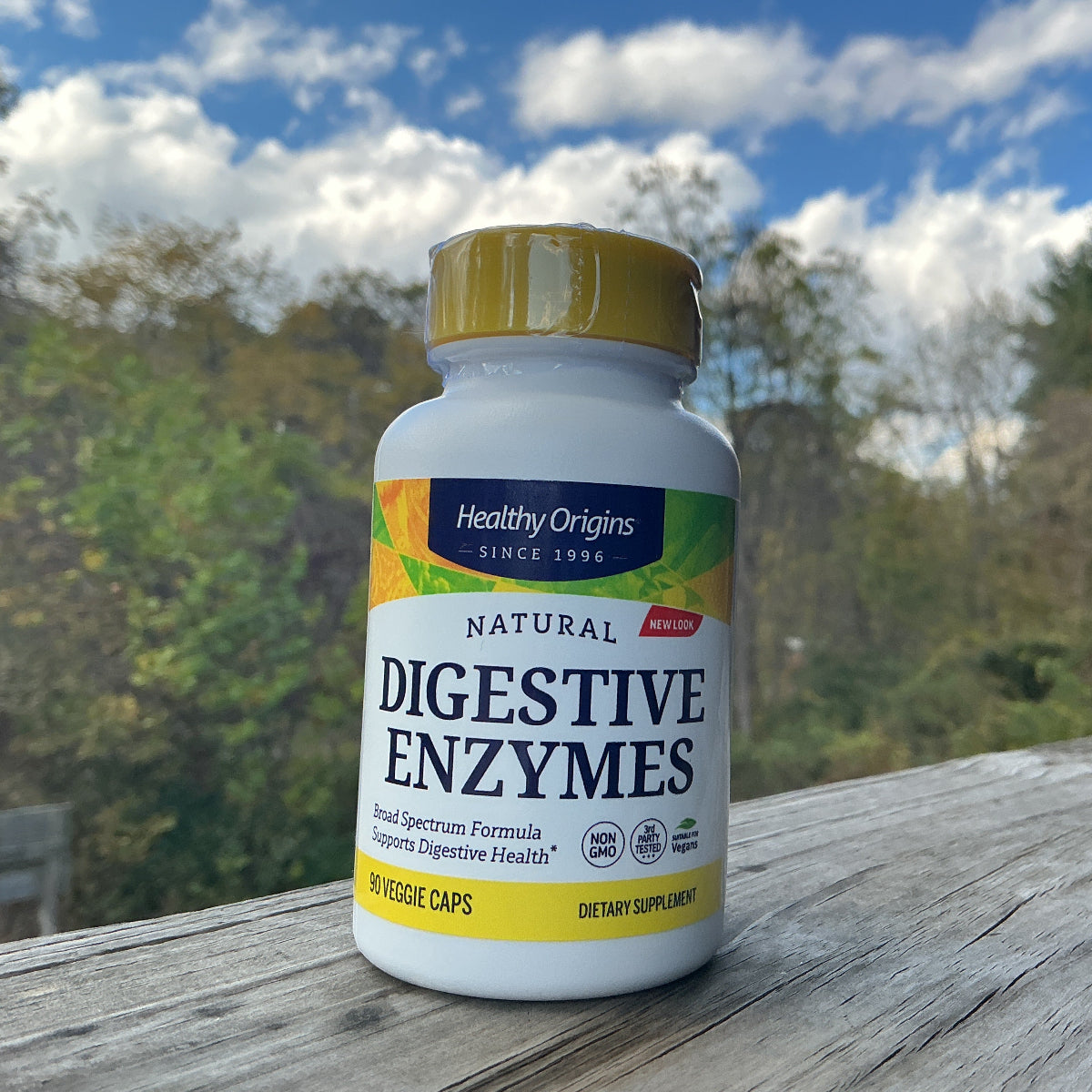 Healthy Origins Digestive Enzymes bottle on a wooden surface with a natural background