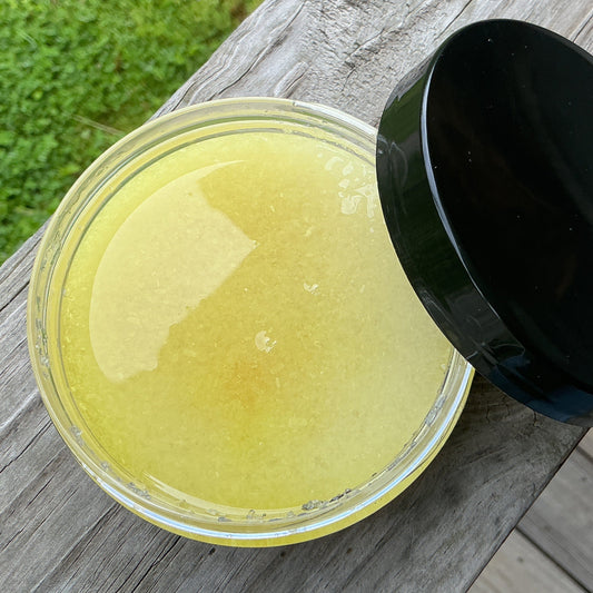 Jar of yellow substance with a black lid on a wooden surface outdoors