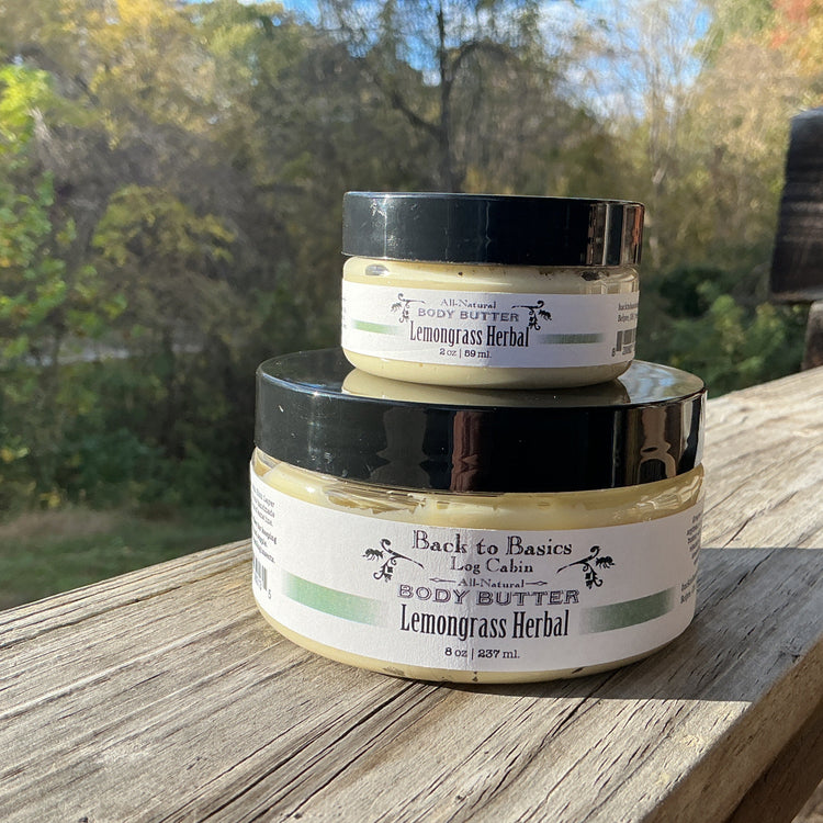 Two jars of Back to Basics Lemongrass Herbal body butter stacked on a wooden surface with a natural background.