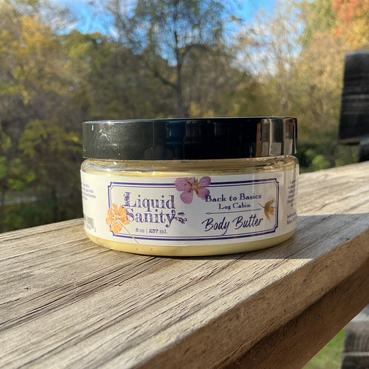 Jar of Liquid Beauty body butter on a wooden surface with a natural background