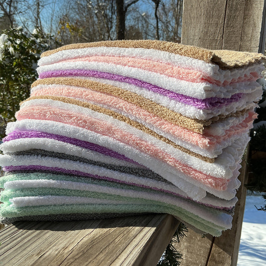 Stack of colorful folded towels on a wooden surface with a snowy outdoor background