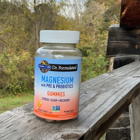 Bottle of magnesium gummies on a wooden surface with a natural background