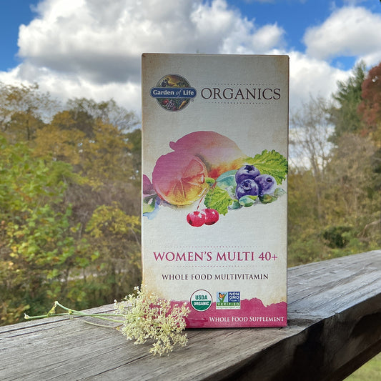 Garden of Life Organics Women's Multi 40+ multivitamin box on a wooden surface with a natural background
