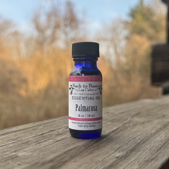 Bottle of Palmarosa essential oil on a wooden surface with a blurred natural background