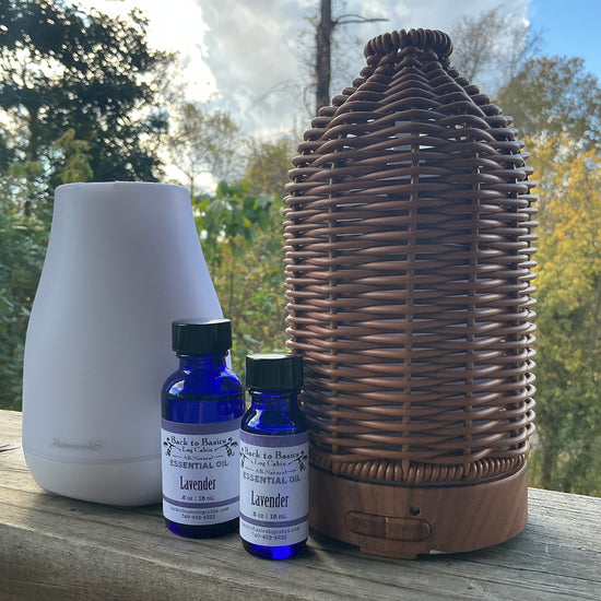 White diffuser, wicker basket, and lavender essential oil bottles on a wooden surface with a natural background.