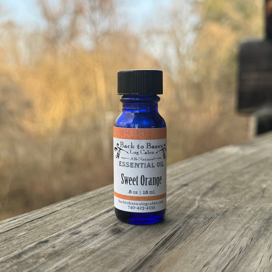 Bottle of sweet orange essential oil on a wooden surface with a blurred natural background