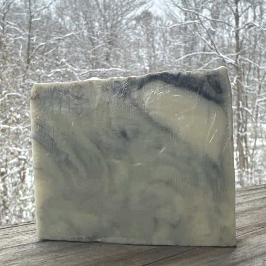 Bar of soap with a marbled pattern on a wooden surface