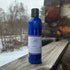 Blue bottle of body lotion on a wooden surface with a snowy landscape in the background