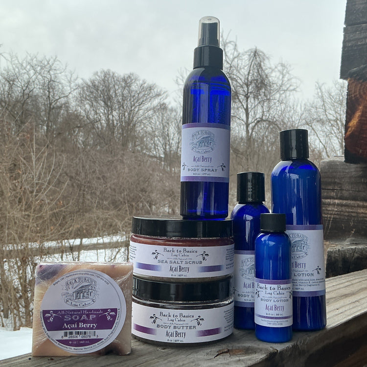 Collection of blue and purple skincare products on a wooden surface with a snowy landscape in the background.