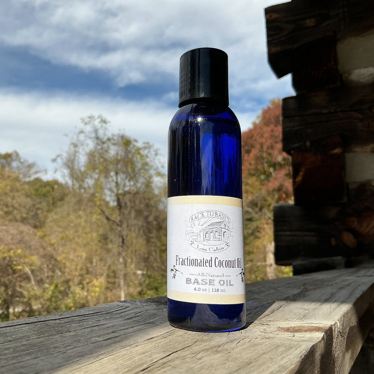 Bottle of Fractionated Coconut Oil on a wooden surface with trees and sky in the background