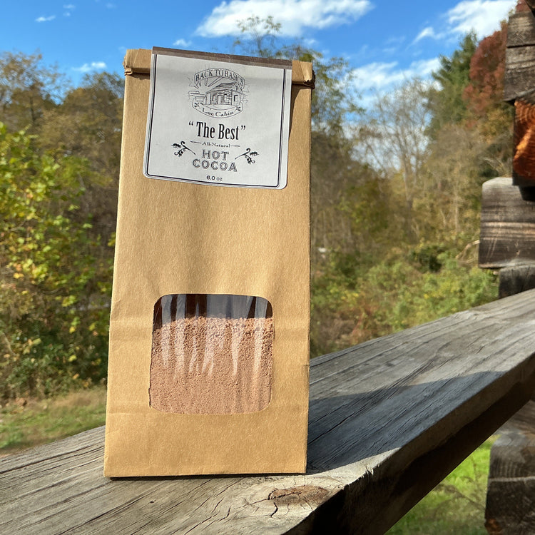 Kraft paper packaging of 'The Best' cocoa on a wooden surface with a natural background