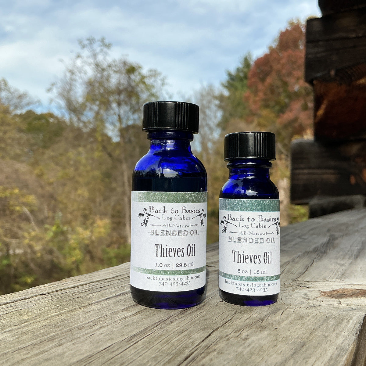 Two bottles of Bach to Basics Thieves Oil on a wooden surface with a natural background