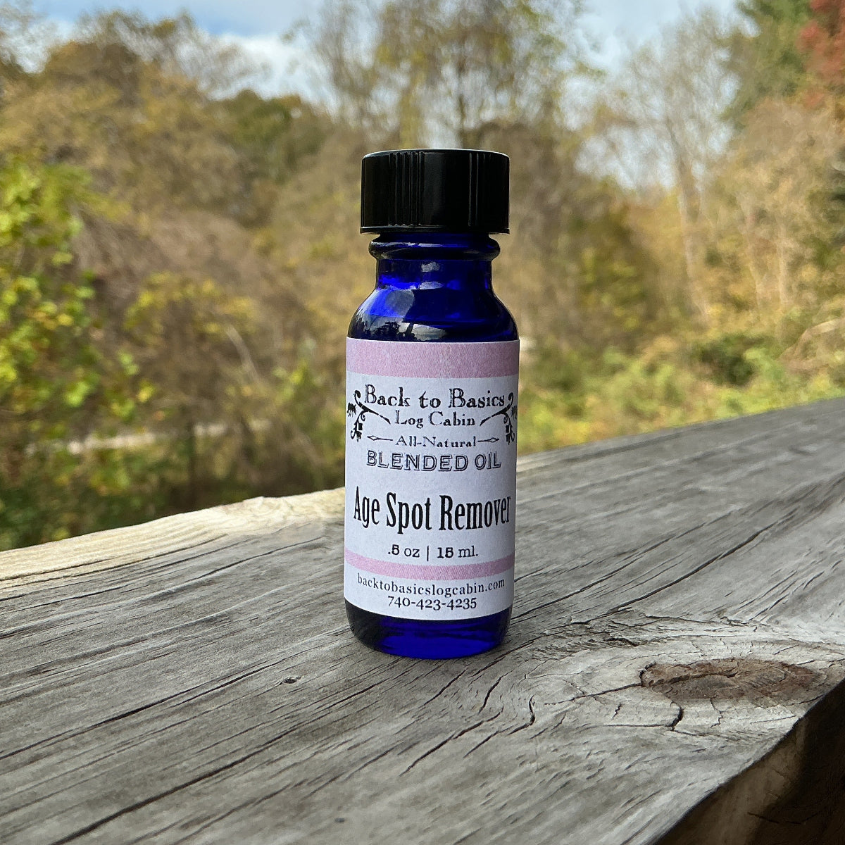Bottle of age spot remover on a wooden surface with a natural background