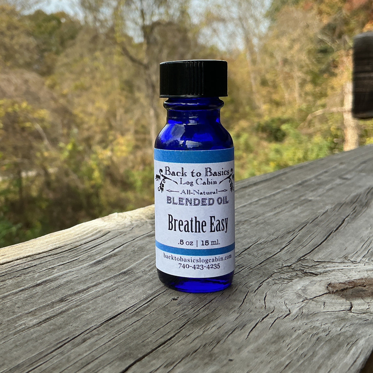 Blue bottle labeled 'Breathe Easy' on a wooden surface with a natural background
