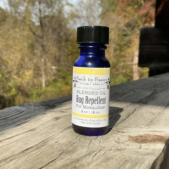 Bottle of Black & Bluestone bug repellent on a wooden surface with a natural background