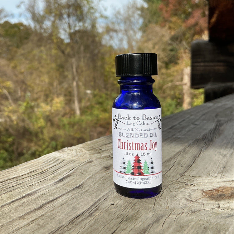 Bottle of 'Christmas Joy' essential oil blend on a wooden surface with a natural background