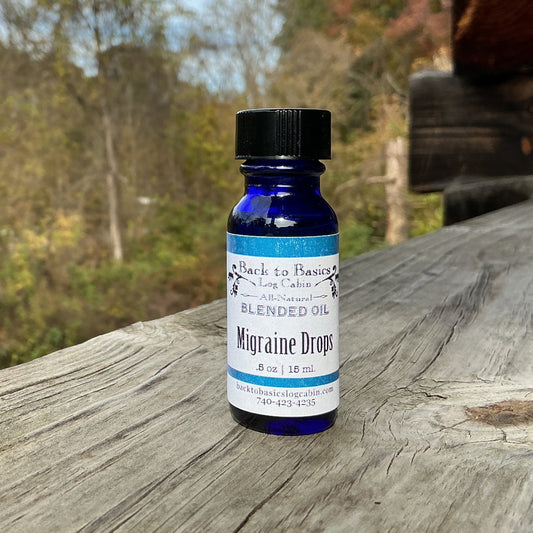 Blue bottle of 'Migraine Drops' on a wooden surface with a natural background