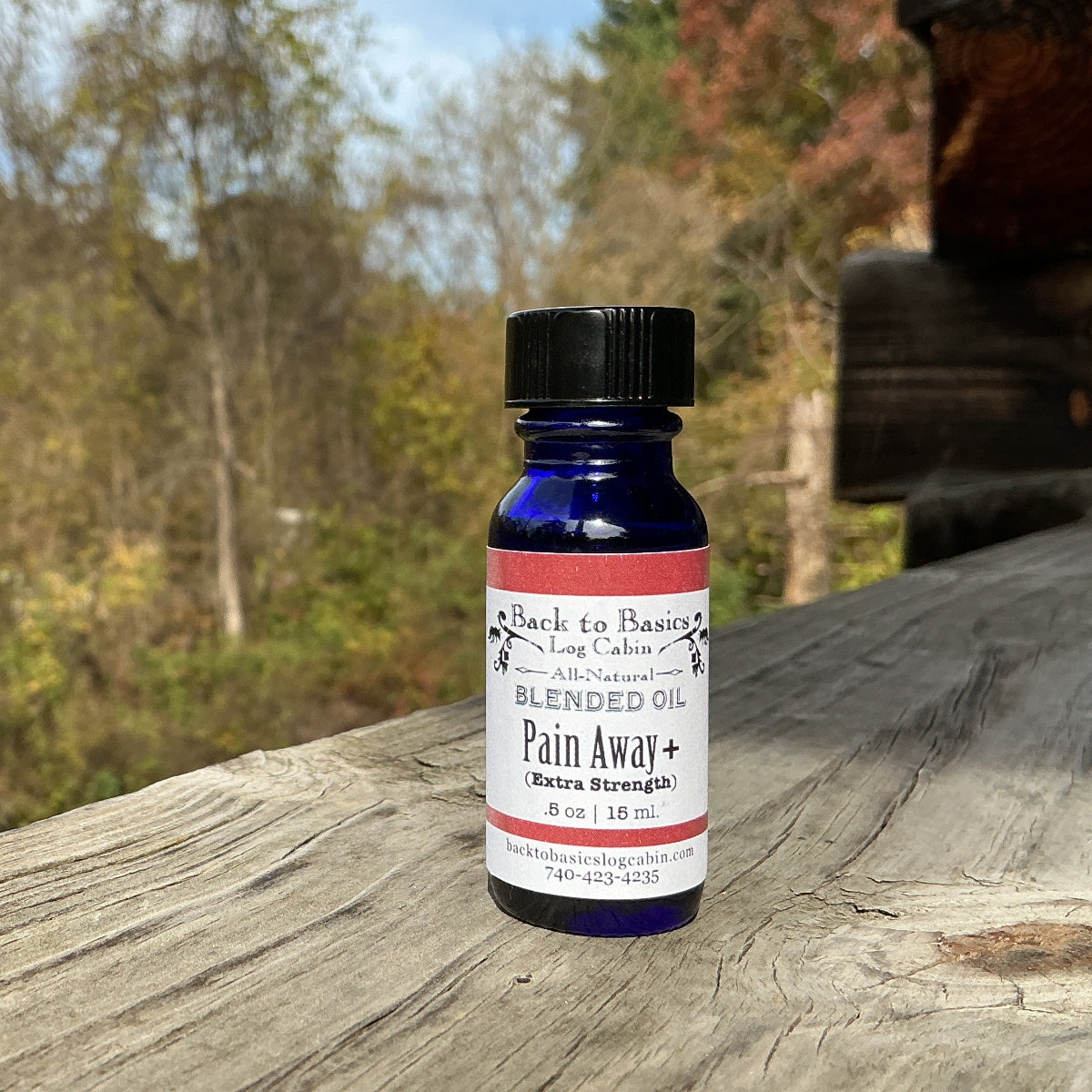 Bottle of 'Pain Away' on a wooden surface with a natural background
