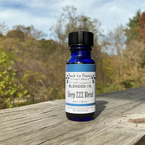 Blue bottle labeled 'Sleep ZZZ Blend' on a wooden surface with a natural background