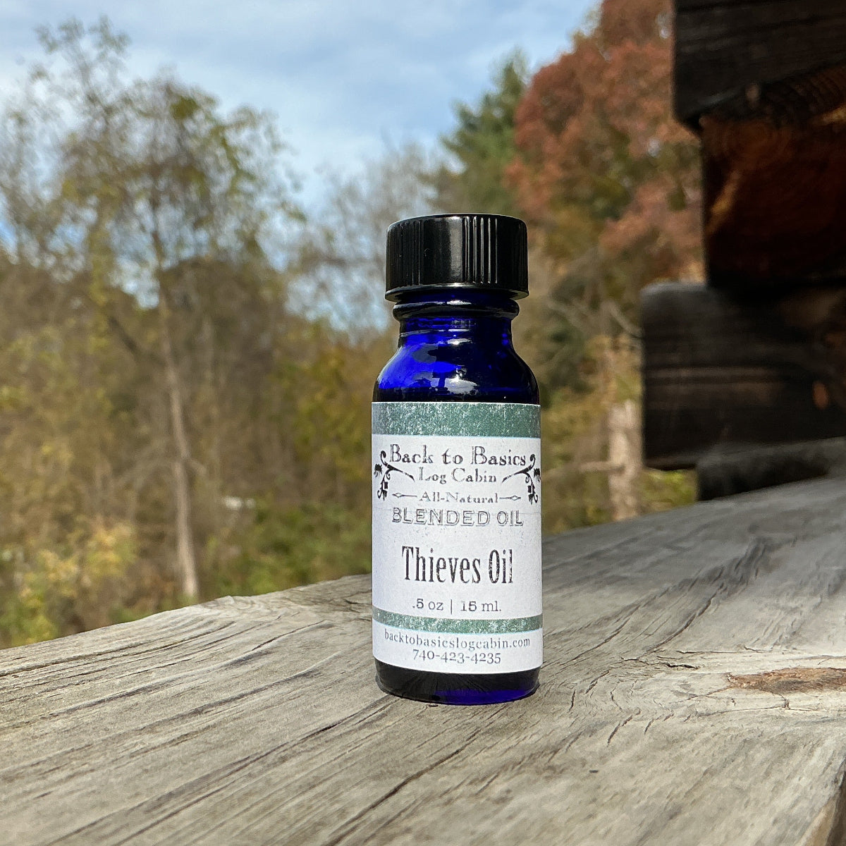 Bottle of Thieves Oil on a wooden surface with a natural background