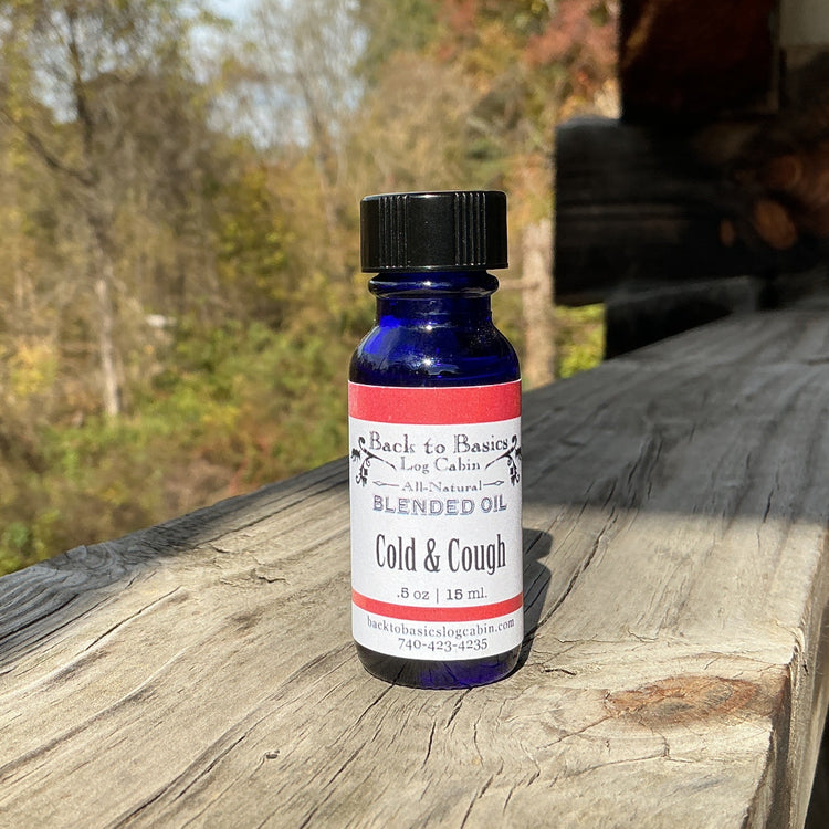 Bottle of 'Cold & Cough' blended oil on a wooden surface with a natural background