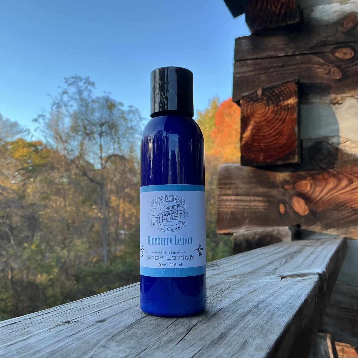 Blue bottle of body lotion on a wooden surface with a natural background