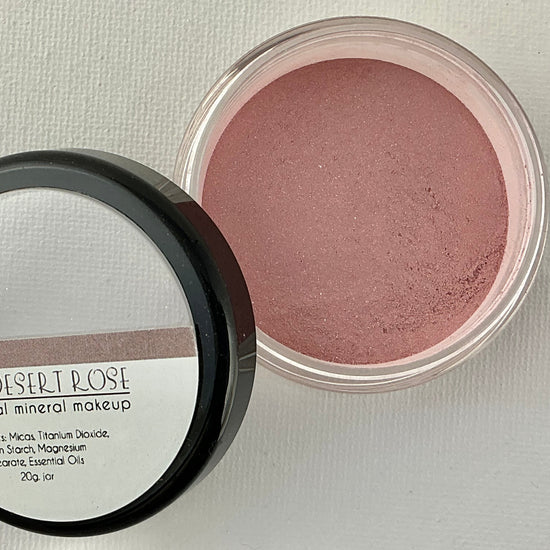 Open container of blush with mirror on a light gray background