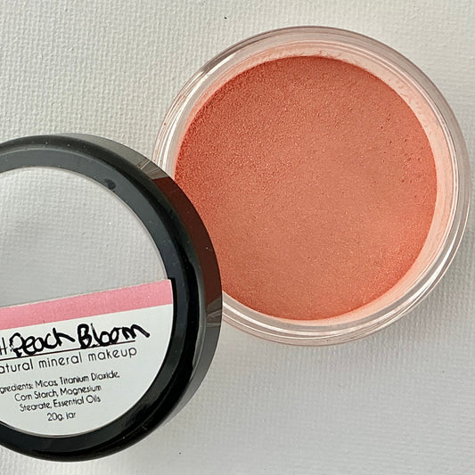 Open container of blush with visible brand name on a light gray background