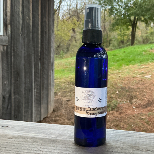 Blue spray bottle with a label on a wooden surface outdoors