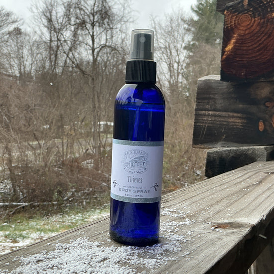 Blue spray bottle with a label on a wooden surface outdoors
