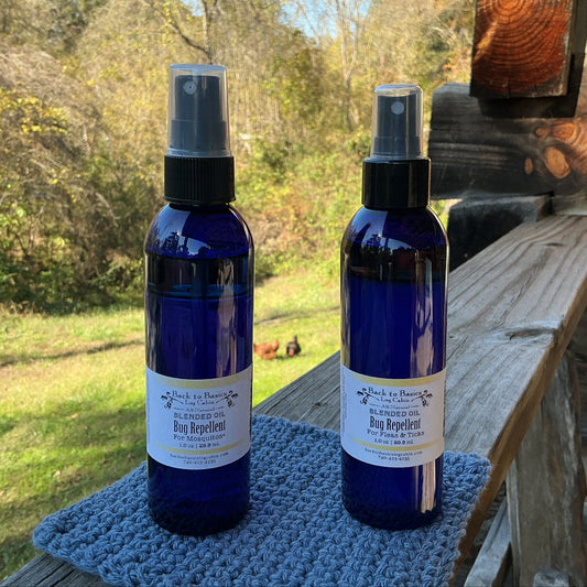 Two blue spray bottles with labels on a wooden surface outdoors.