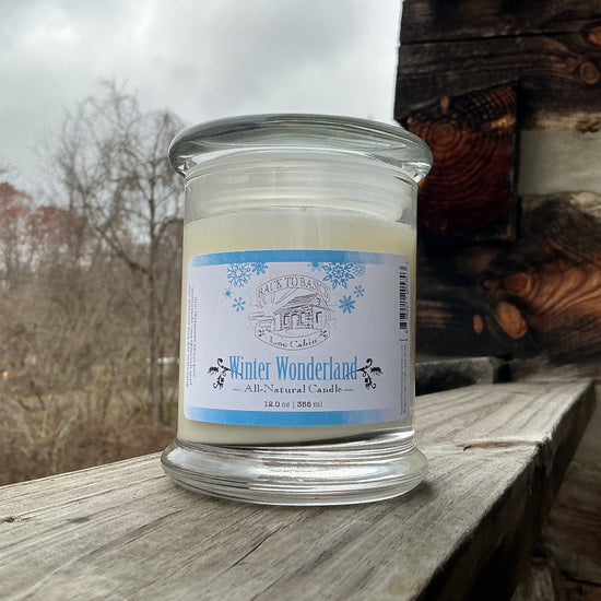 Candle in a glass jar with a label on a wooden surface outdoors