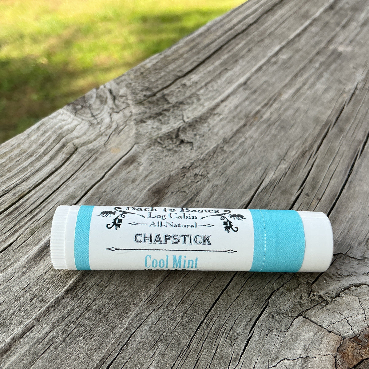 Chapstick stick on a wooden surface with 'Long Cabin' branding