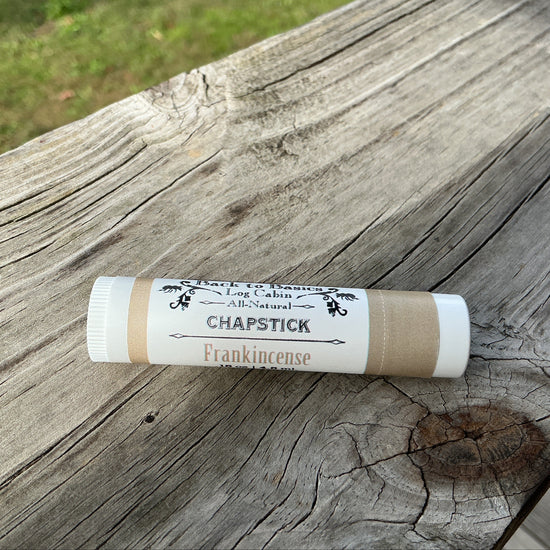 Chapstick stick on a wooden surface with grass in the background